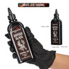 Hand holding GTARTISTOO Superb Black Tattoo Ink 10oz bottle, deep black tattoo ink for smooth control, lining, shading, packing, and solid black fills.